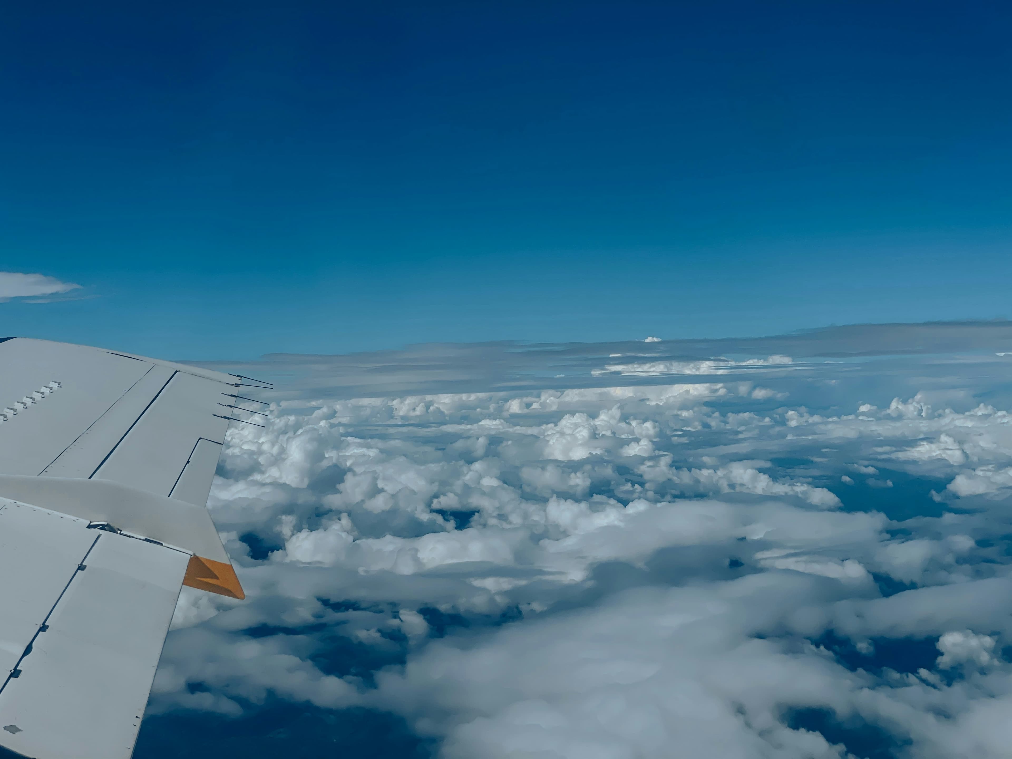 Airplane flying above clouds representing international travel and foreign tour opportunity